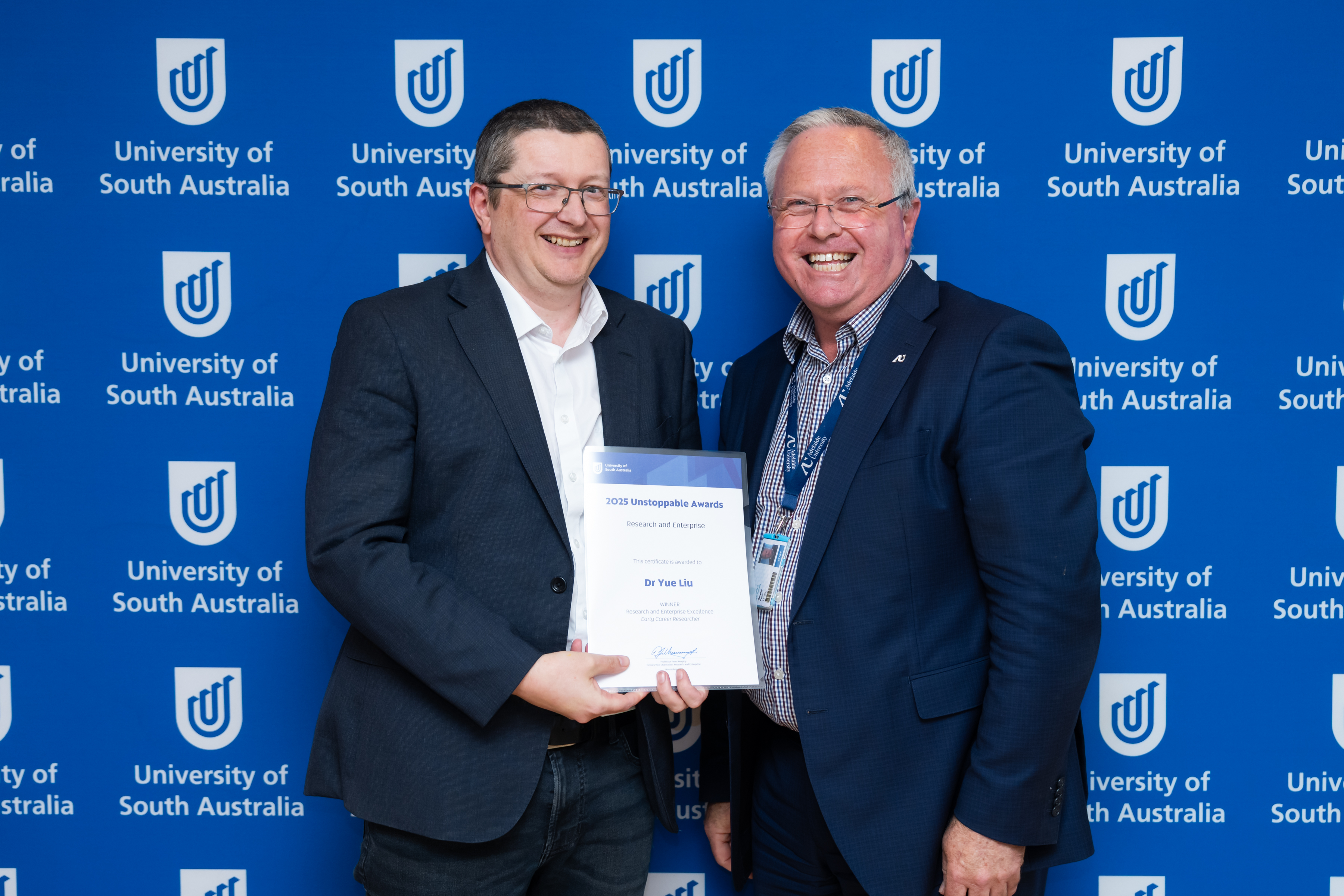 Professor Jason Whittle, Dean of Research in UniSA STEM, accepts the Early-Career Researcher Award on behalf of Dr Yue Liu from the Deputy Vice Chancellor: Research & Enterprise, Professor Peter Murphy