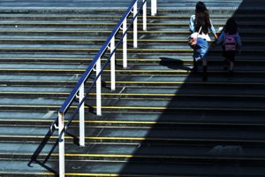 A woman and childwalking up a large set of outdoor stairs