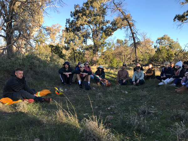 Travis Thomas shares his knowledge of fire safety with students before leading a cultural burn.