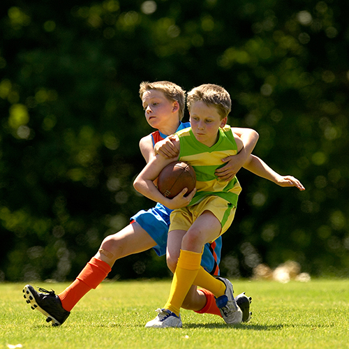 Junior AFL players in a tackle